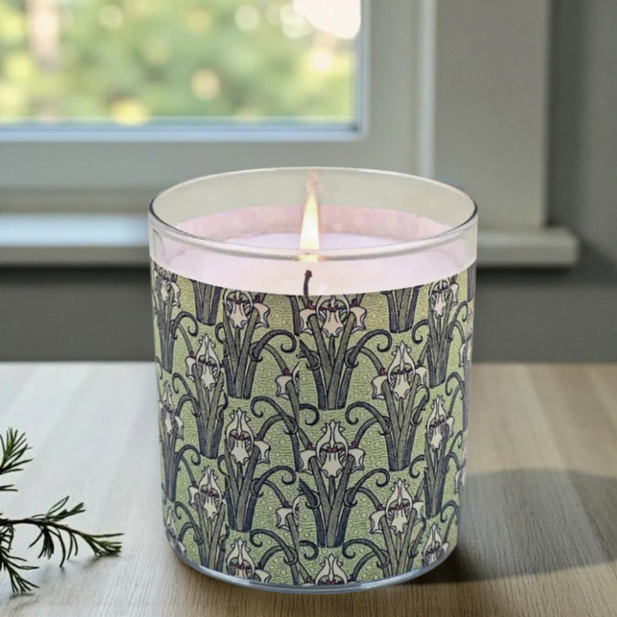 Candle with a decorative pattern on a table near a window