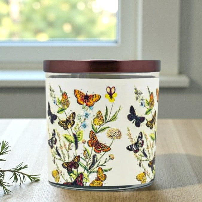 Candle with butterfly design on a windowsill