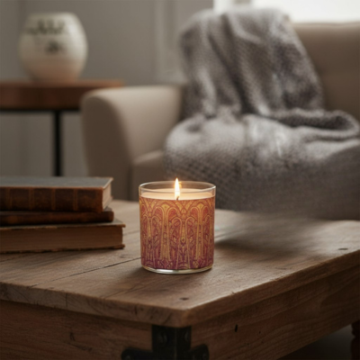 Candle with decorative packaging on a wooden table in a cozy living room.