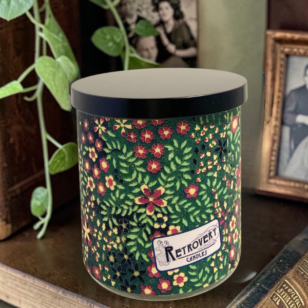 Decorative candle with floral pattern and 'Retrovert Candle' label on a surface.