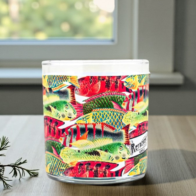 Colorful candle with fish design on a table near a window