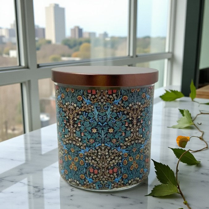 Decorative candle with intricate pattern on a marble surface near a window with a cityscape view.