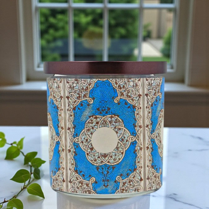 Decorative candle with blue and brown pattern on a marble surface
